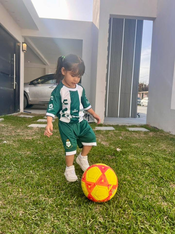 Niña con el uniforme del Santos y un balón